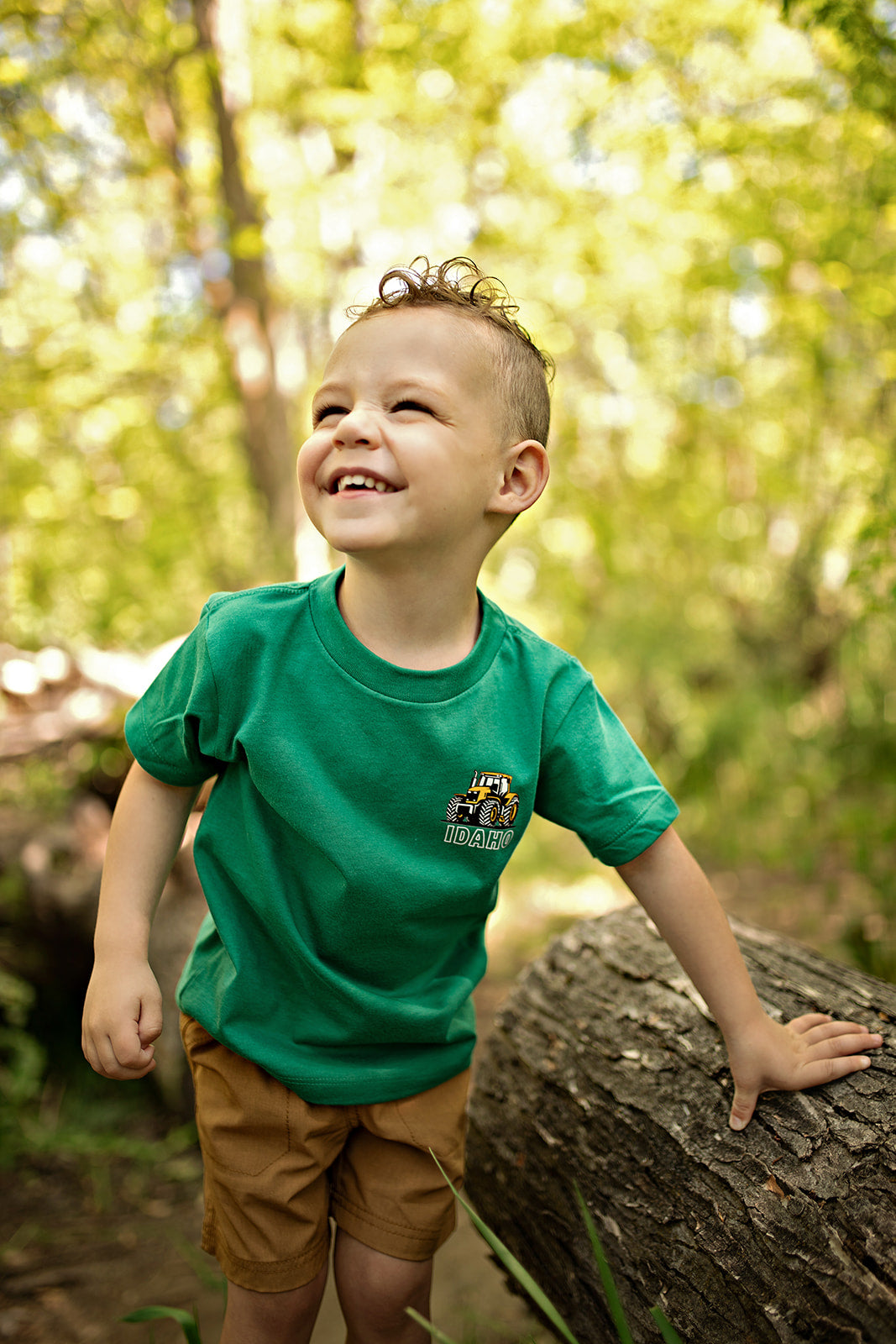 This adorable green t shirt is made for those Idaho kids. This Idaho T shirt has a tractor on the front and the back, with the words Idaho proudly across it. This t shirt has a yellow tractor with the words TatorJo Farm and Ranch across the back. It is super soft and the cutest!