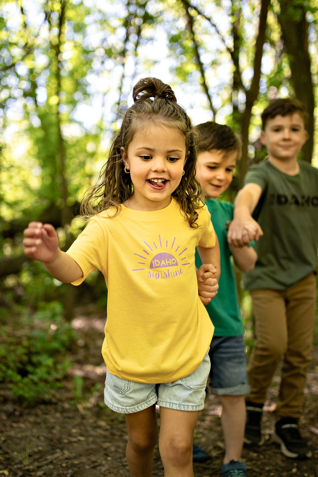 This Idaho Sunshine shirt is the perfect summer tee for any Idaho kid. It is bright yellow and has Idaho Sunshine in purple across it. This Idaho T shirt is designed by TatorJo and made for Idaho kids. It is durable and soft and ready for epic Idaho outdoor adventures.