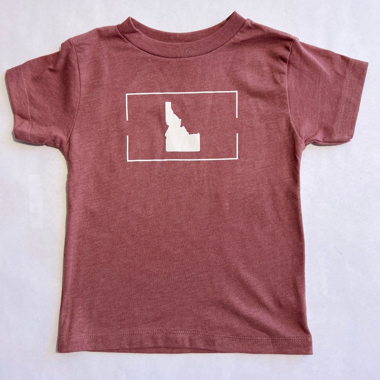 This Idaho T shirt comes in mauve, a pretty light mauve that can be dressed up and down. The t shirt has Idaho printed on it. This Idaho T Shirt has a simple Idaho design. This shirt showcases the love for Idaho. TatorJo designs and prints these Idaho t shirts in Idaho. TatorJo is an Idaho Apparel Company focused on creating durable clothing for kids and adults.