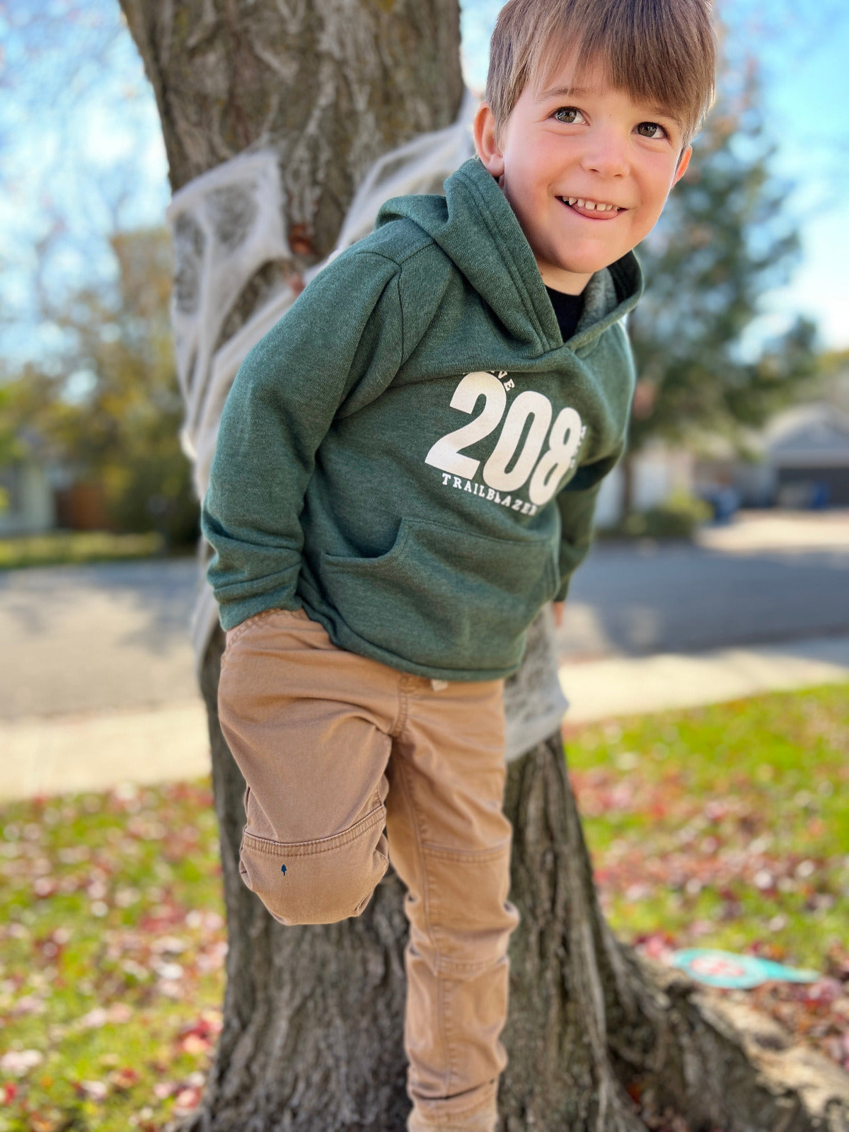 A little boy wearing a cozy and warm hoodie that states 208. This number serves as a symbol to Idaho. Sold by TatorJo.