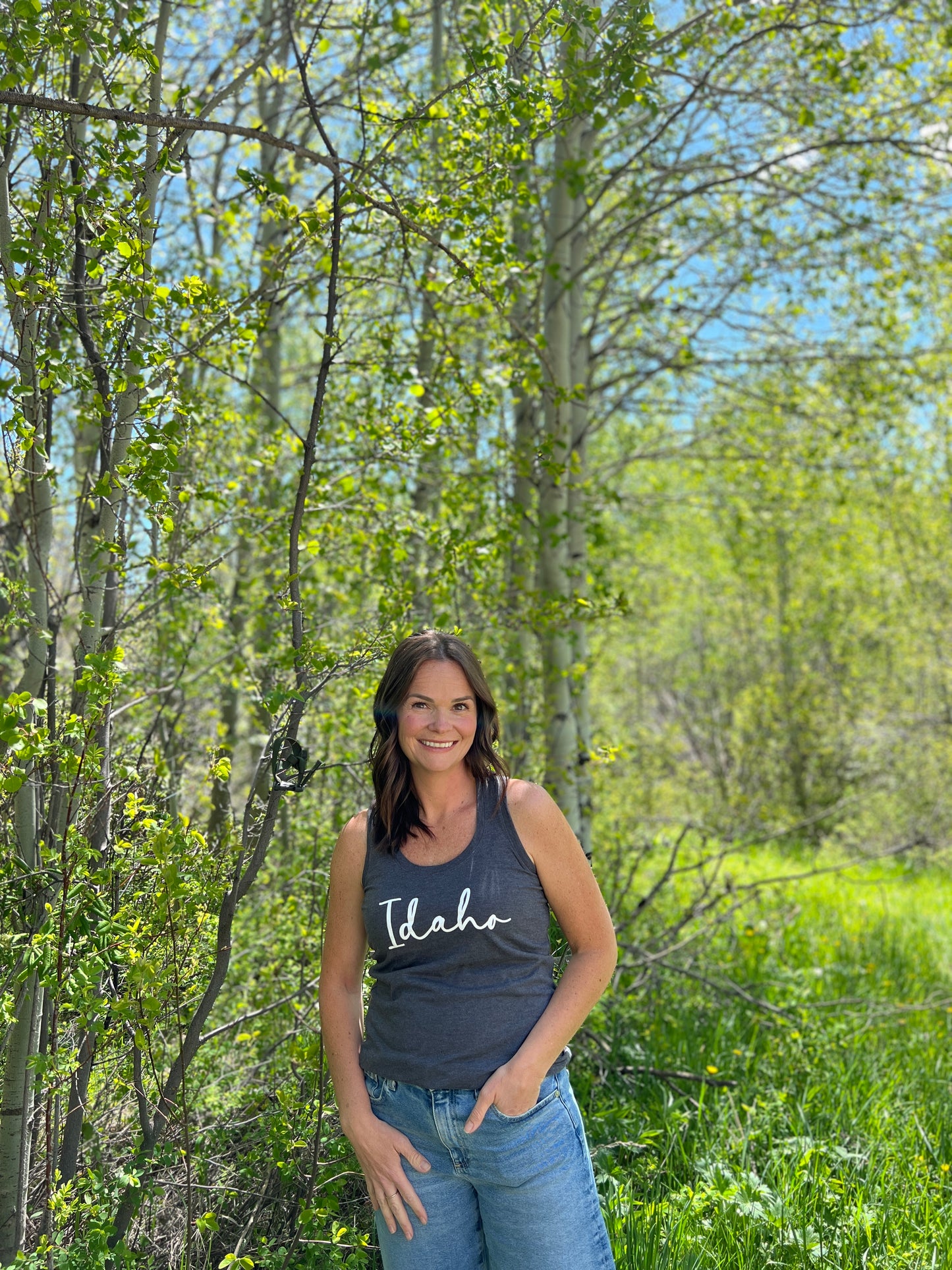 This cute Idaho tank top comes in a triblend material. The woman is wearing a tank top that says Idaho.