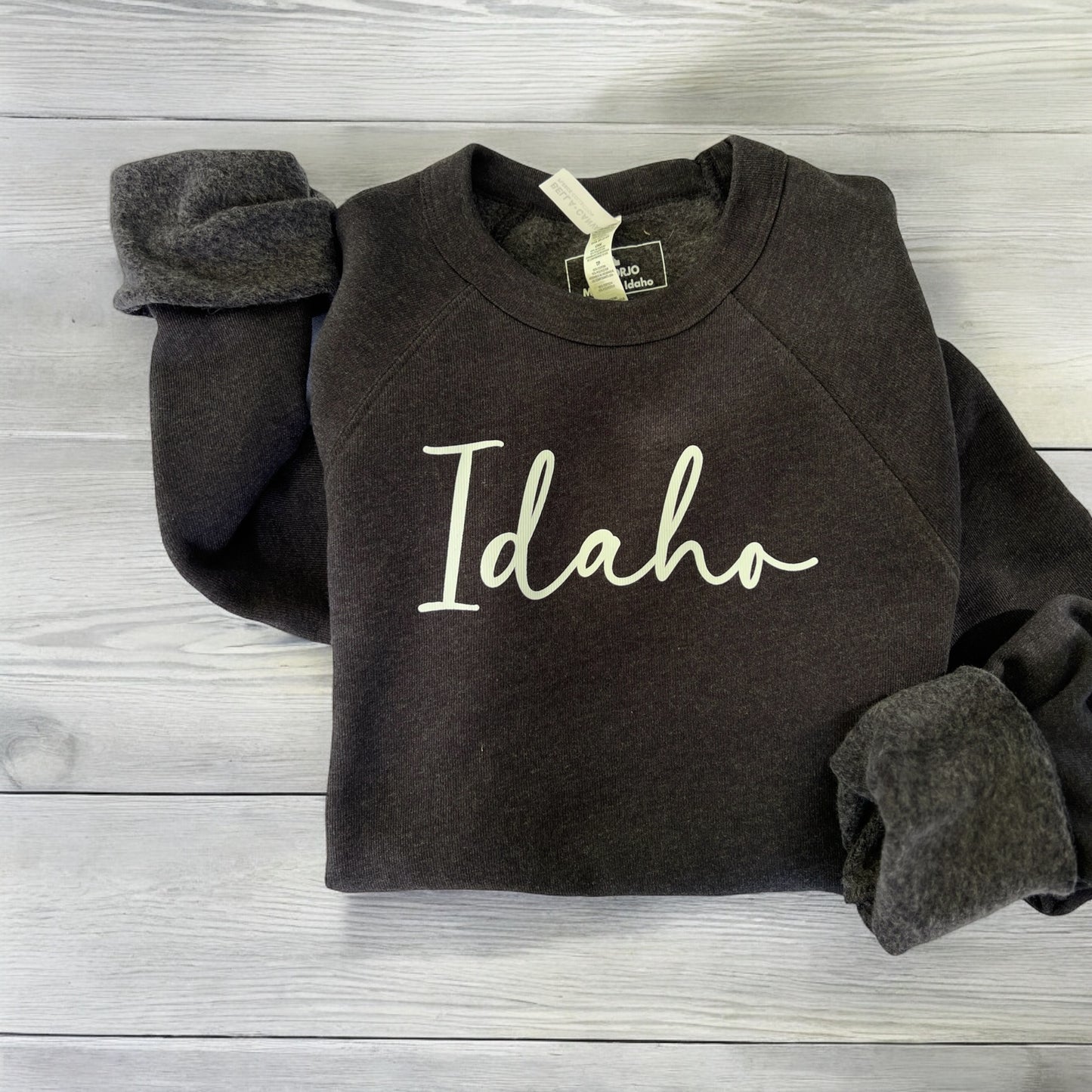 This Idaho sweater is a must own if you live in Idaho. This Heather Black Idaho Crewneck has a classy Idaho design on the front. This sweater is designed by TatorJo, an Idaho Clothing Company.