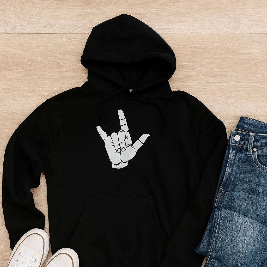 Black hoodie with a Idaho white graphic design, paired with white sneakers and blue jeans on a wooden surface.