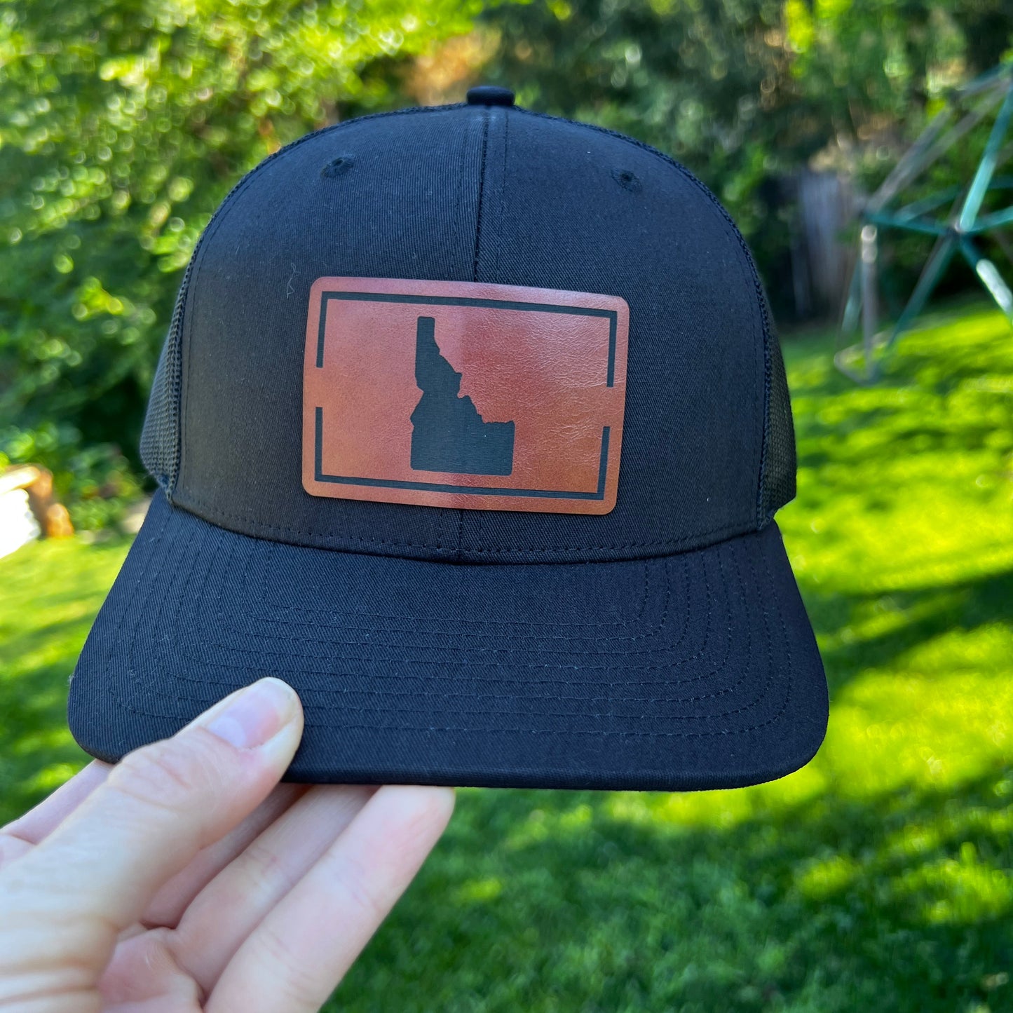 Black Idaho cap with a brown leather patch. The leather patch is a Idaho symbol