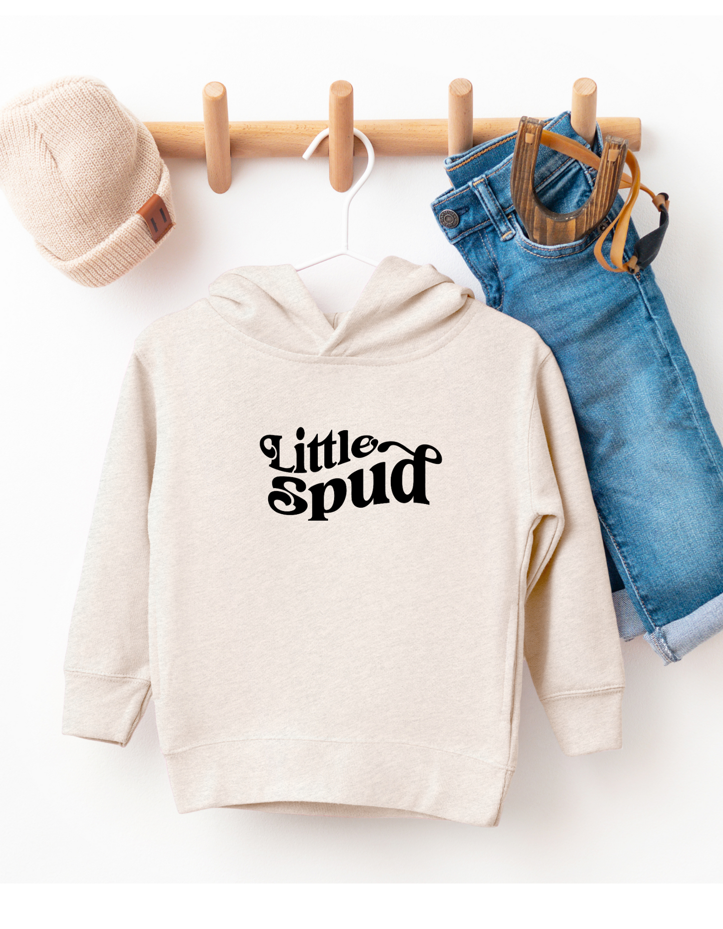 This adorable Little Spud hoodie is hanging on a hanger showing off it's cute design. This Idaho sweater is designed by TatorJo, an Idaho company.