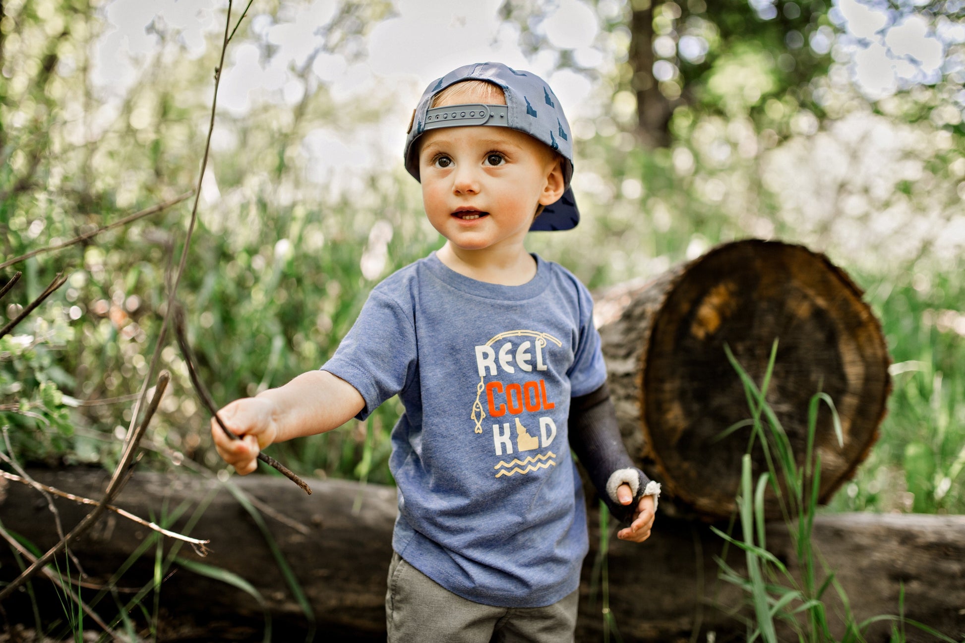 A boy wearing a Reel Cool Kid shirt that represents Idaho.