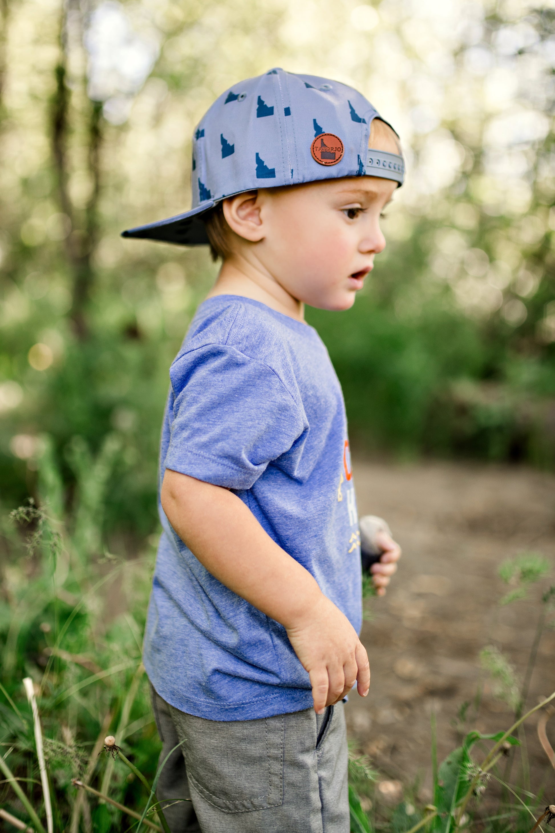 An idaho boy wearing an Idaho t shirt that says Reel Cool Kid. The boy is also wearing an Idaho hat!