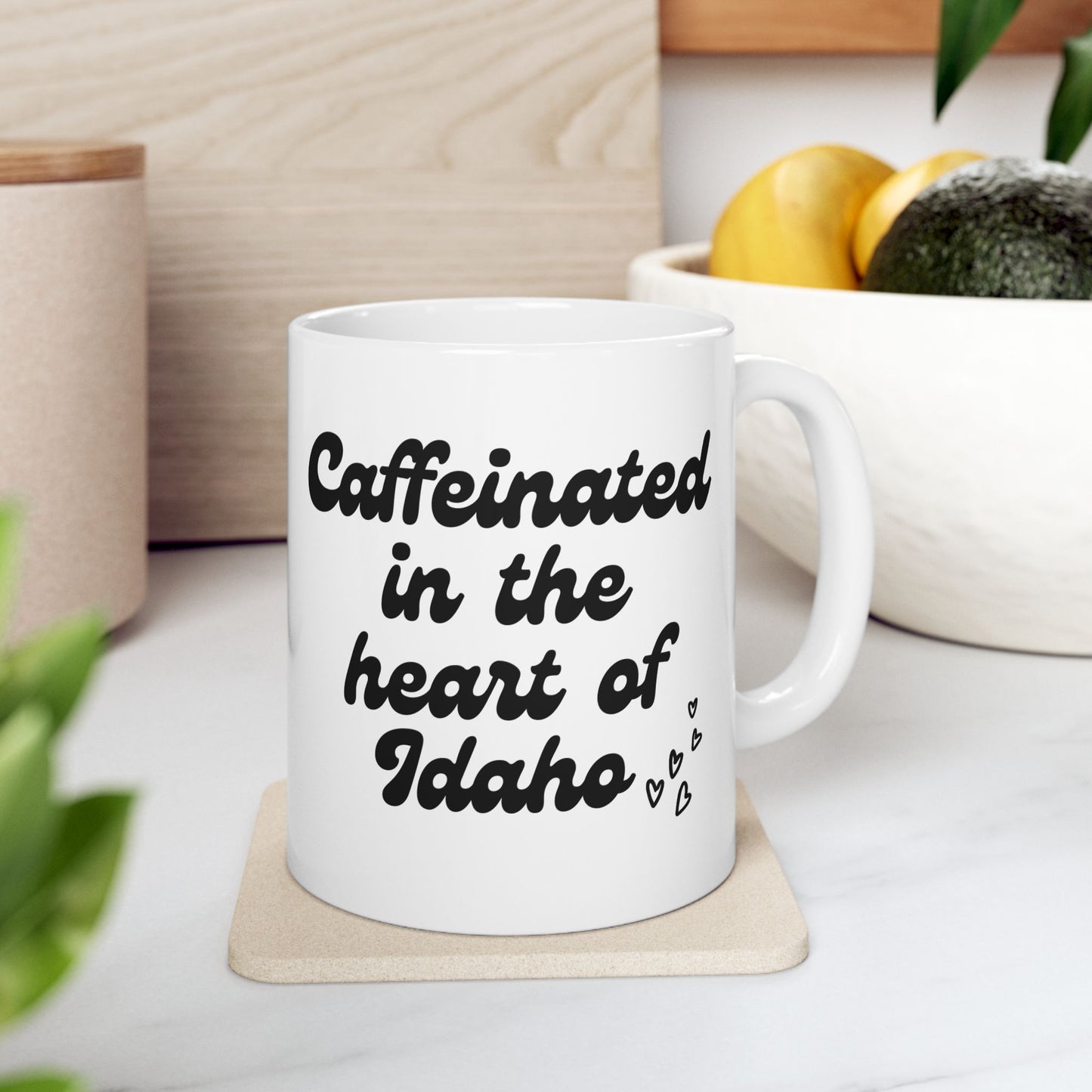 This white coffee mug has the saying Caffeinated in the heart of Idaho on it. It is a coffee mug that represents Idaho. This coffee mug would be a perfect gift. 