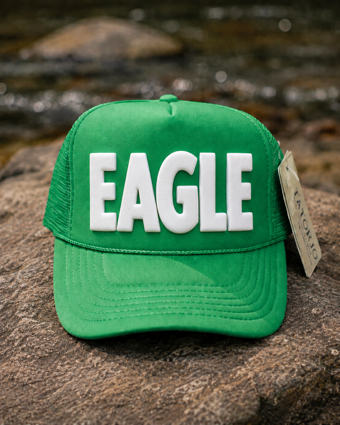 Green cap with 'EAGLE' text on a rock surface