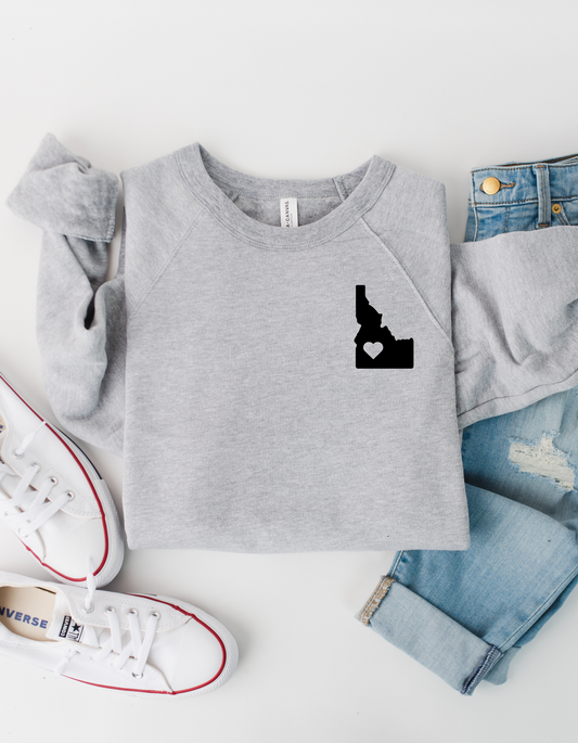 This gray Idaho sweater has a cute design on it. The design has an Idaho on it with a little heart inside of it. This Idaho clothing is cozy and comfortable. This Idaho sweater is designed for Idaho moms. 