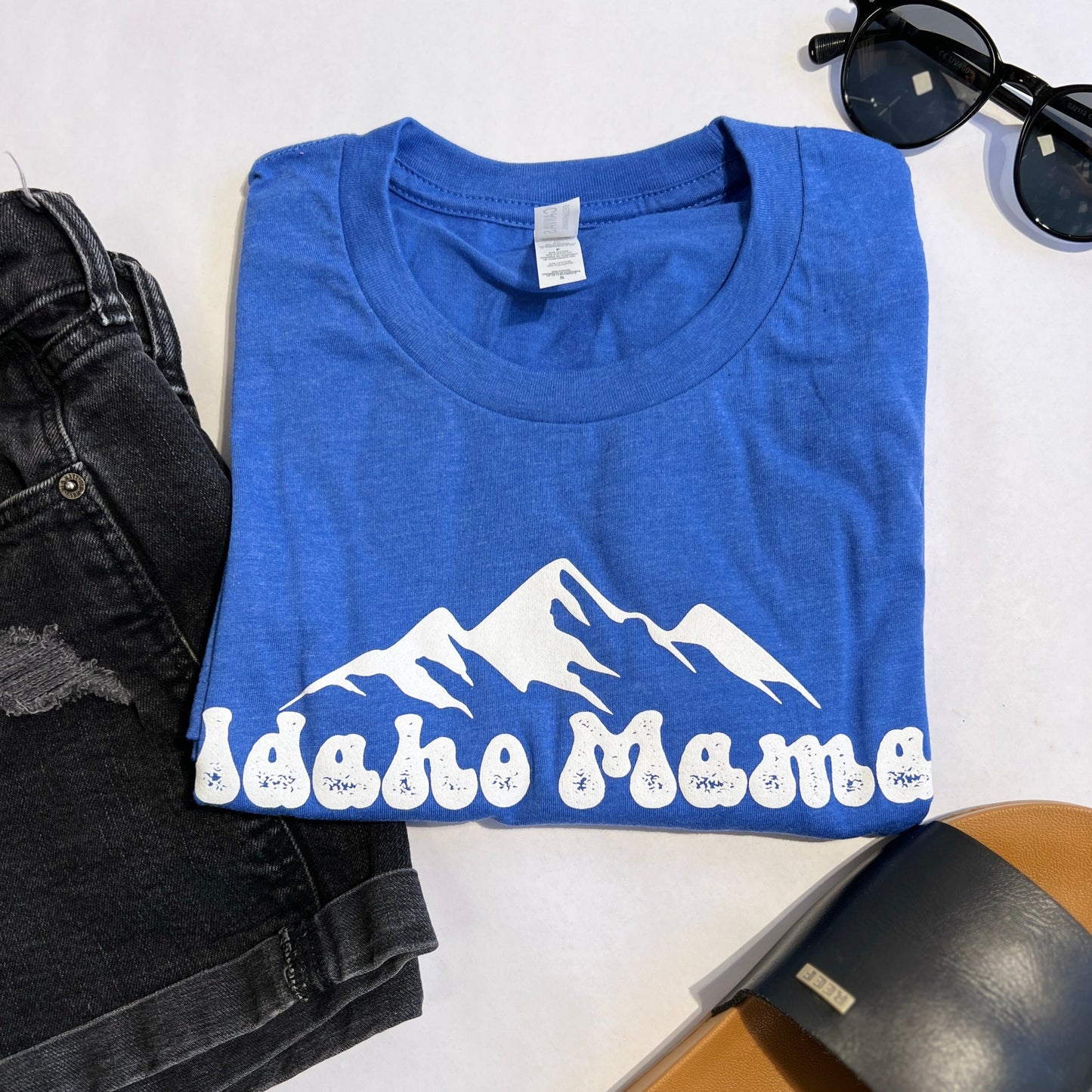 This blue Idaho Mama T Shirt is a perfect addition to any Idahoans closet. This Idaho T shirt has Idaho Mama on it, it comes in a comfortable and stretchy fabric. This blue is bright and goes well with black or white pants. This shirt is designed by TatorJo, an Idaho Apparel Clothing Company. This Idaho Shirt is screen printed in Idaho.