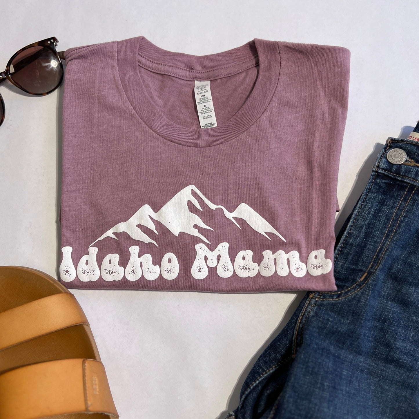 Idaho Mama shirt in Sage green. This cute Idaho Mama shirt is a cute style that can be dressed up or down. This t shirt is designed right here in Idaho by an Idaho Apparel Company. This Idaho T Shirt showcases the adventure an Idaho pride. The letters on the Idaho T shirt say Idaho Mama. Idaho T Shirt in Purple