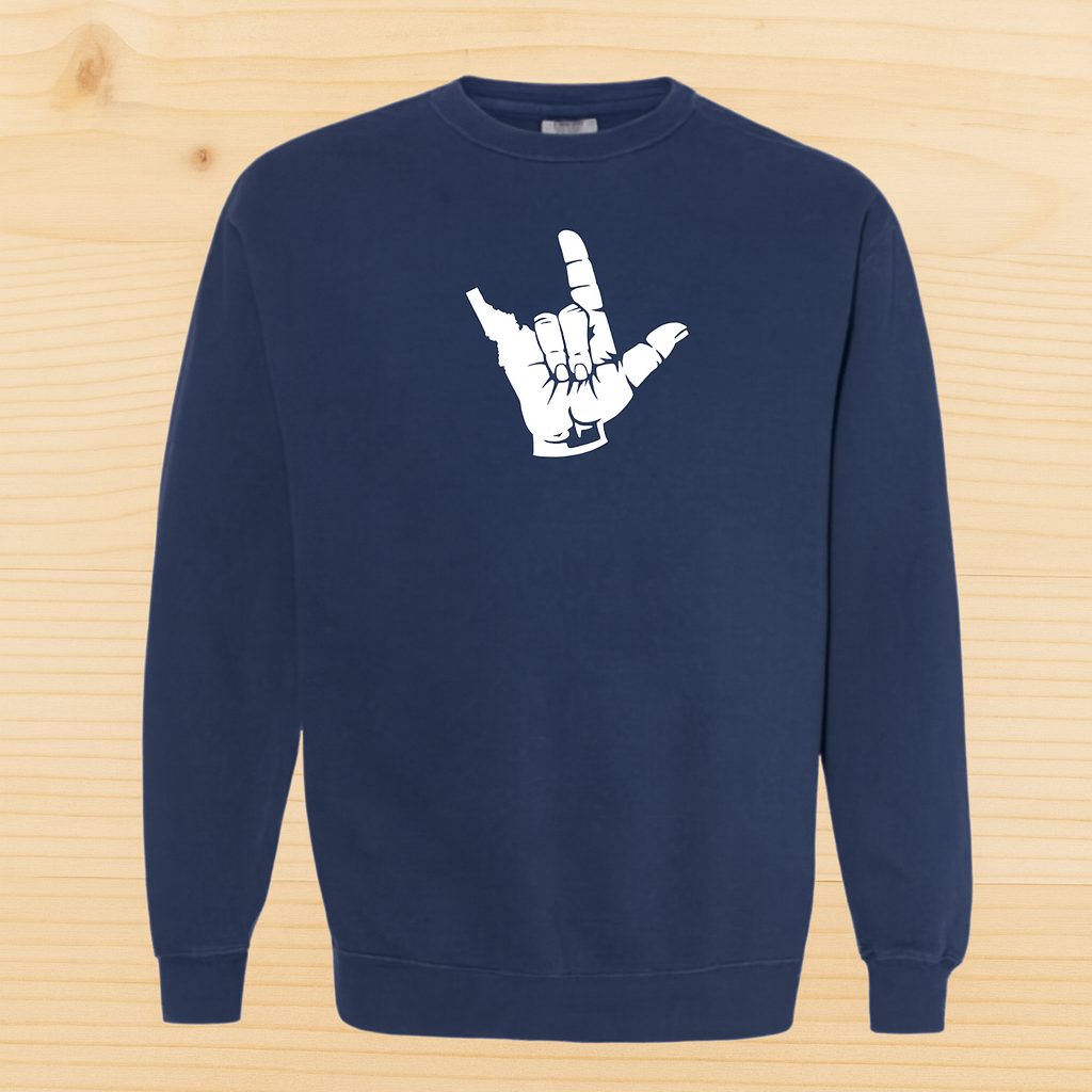 Navy blue Idaho sweatshirt with a white hand gesture design on a wooden surface
