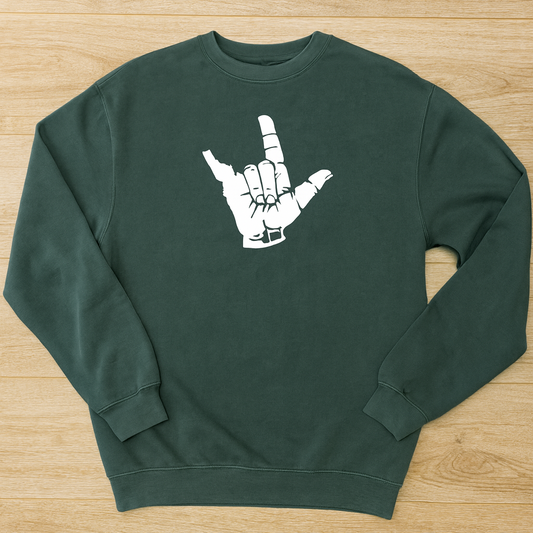 Green Idaho sweatshirt with a white graphic on a wooden surface
