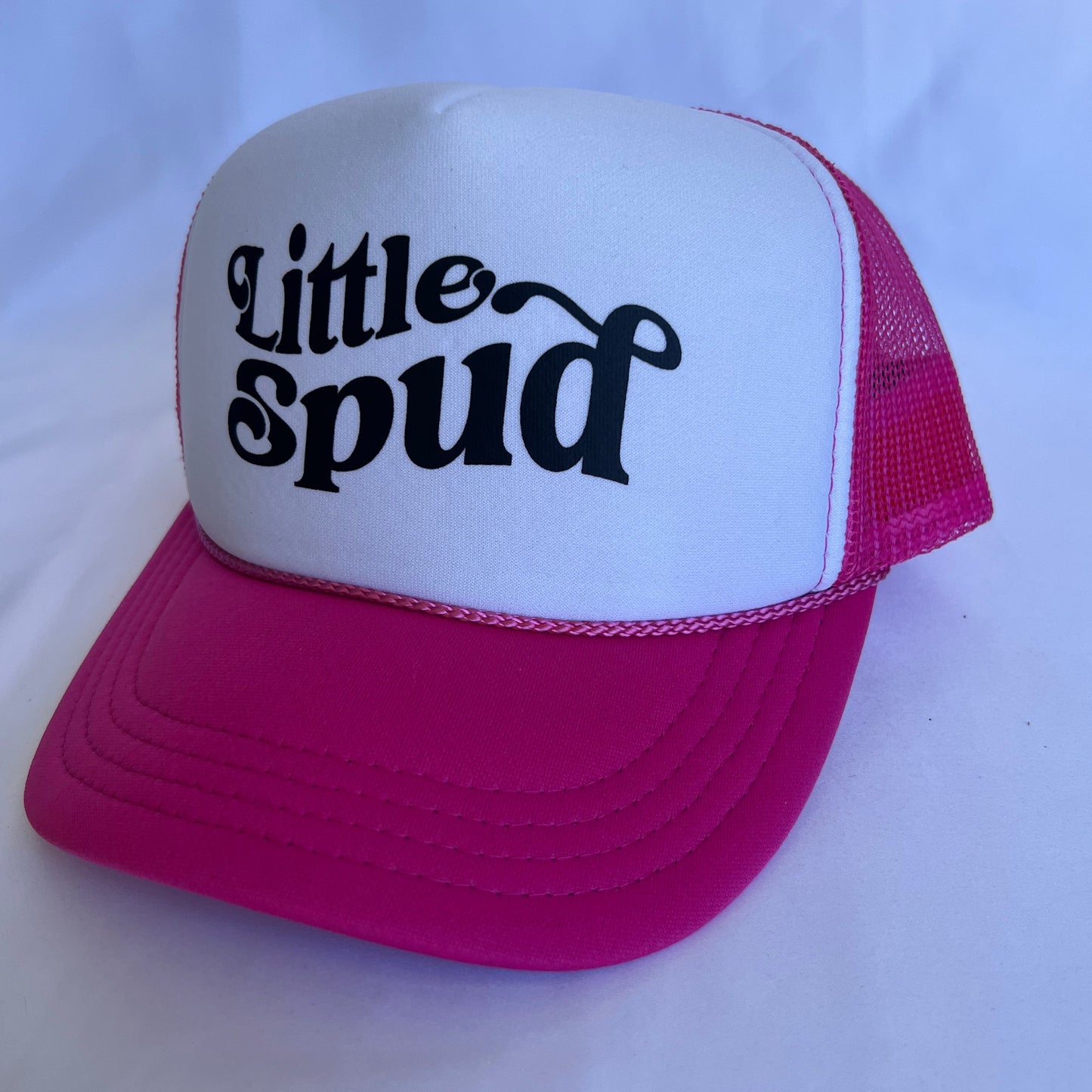 Pink and white cap with 'little spud' text on a white background