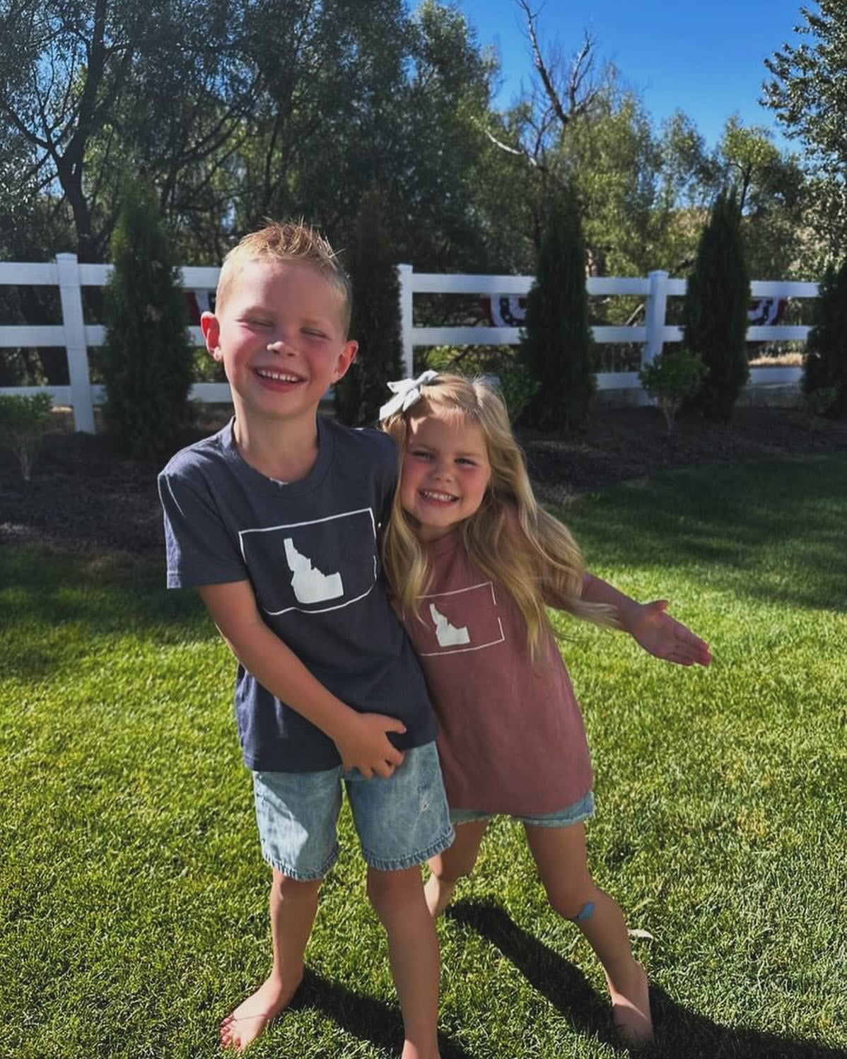 Two Idaho kids playing outside in their Idaho shirts. They kids are brother and sister and hugging! Designed in Idaho and printed by TatorJo