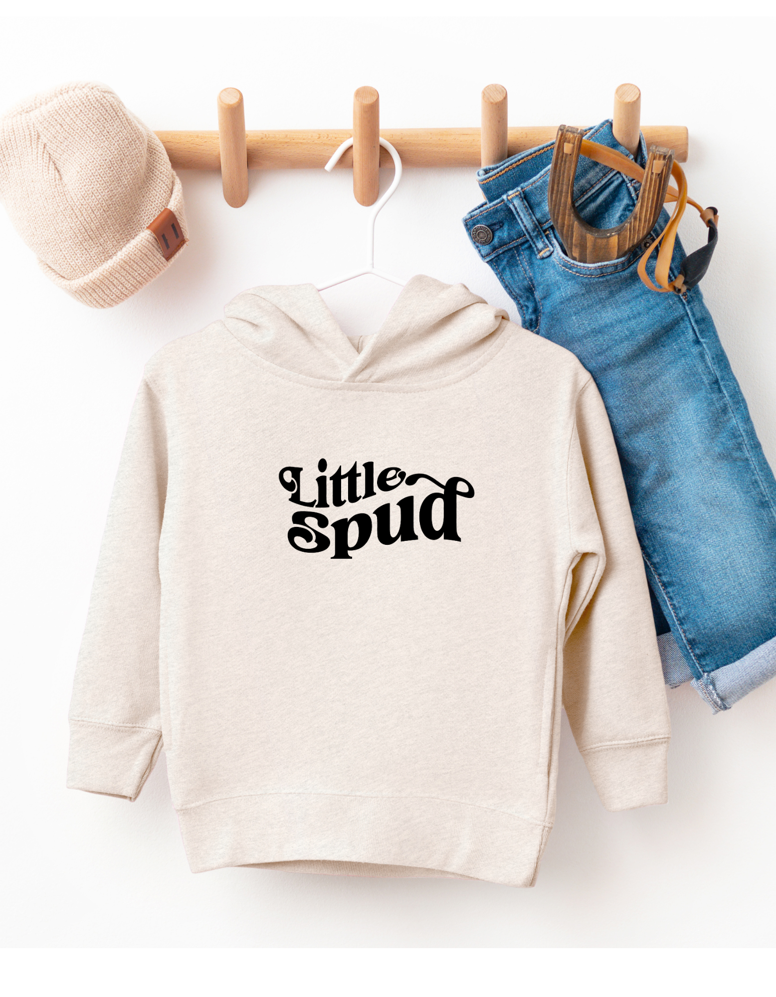 This adorable Little Spud hoodie is hanging on a hanger showing off it's cute design. This Idaho sweater is designed by TatorJo, an Idaho company. 