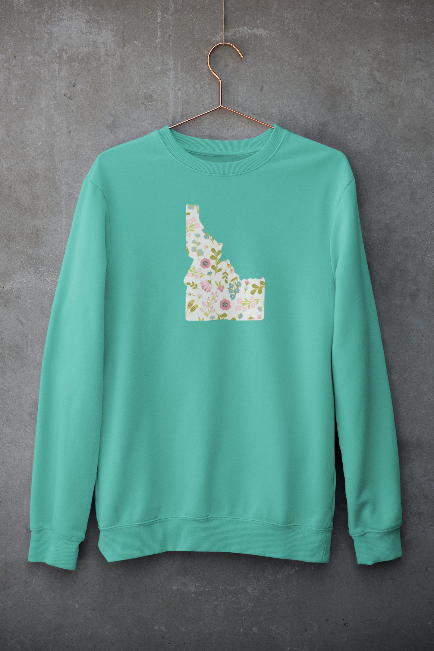 Green sweatshirt with a floral Idaho map design on a gray background